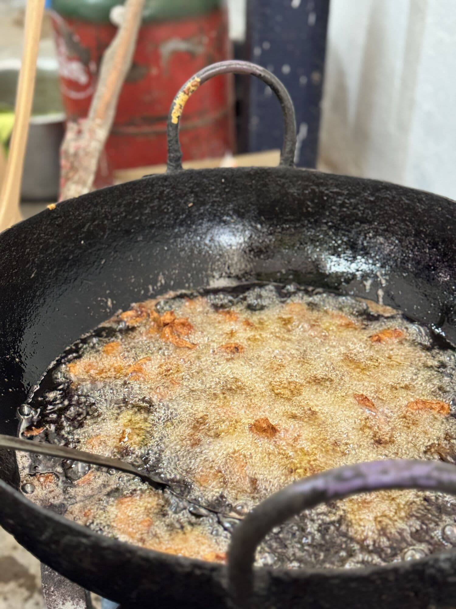 Pieces frying in a big kadai at a live counter