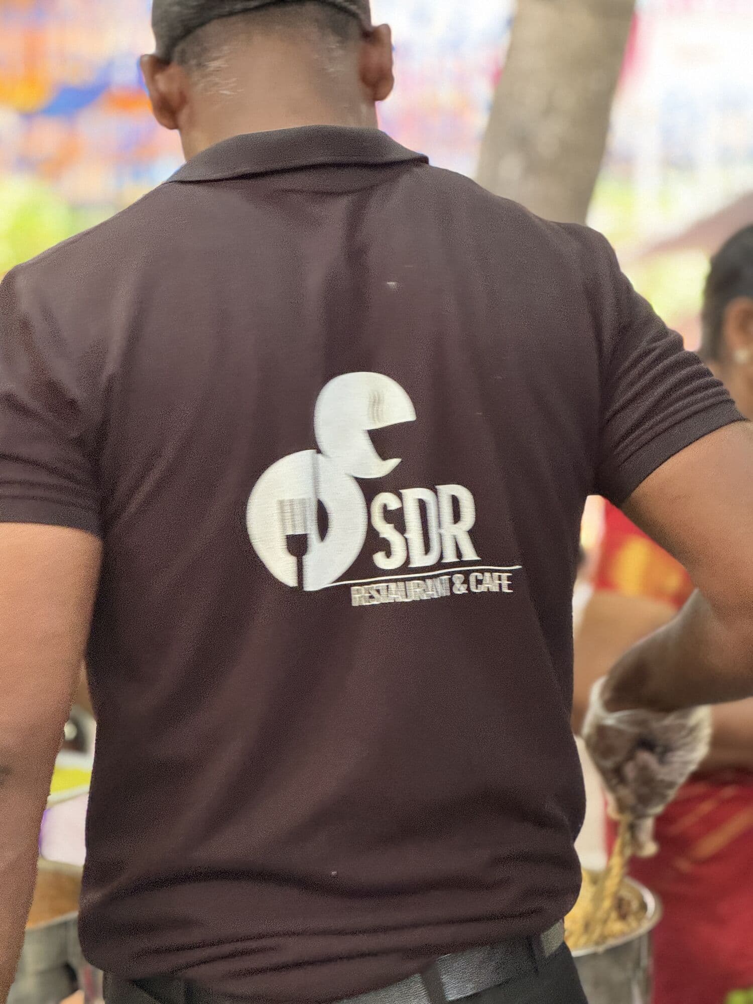An SDR team member in a branded uniform serving at an event